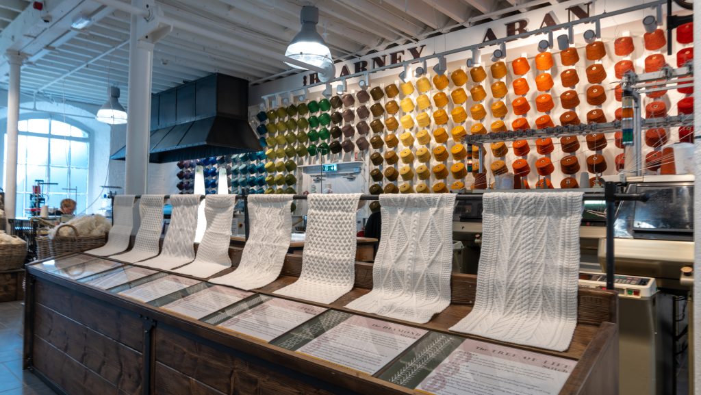Samples of Aran Knitting with wall of coloured yarn