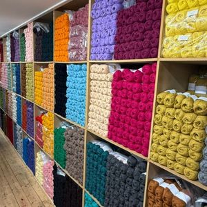 Stacks of yarn on shelves in various colours