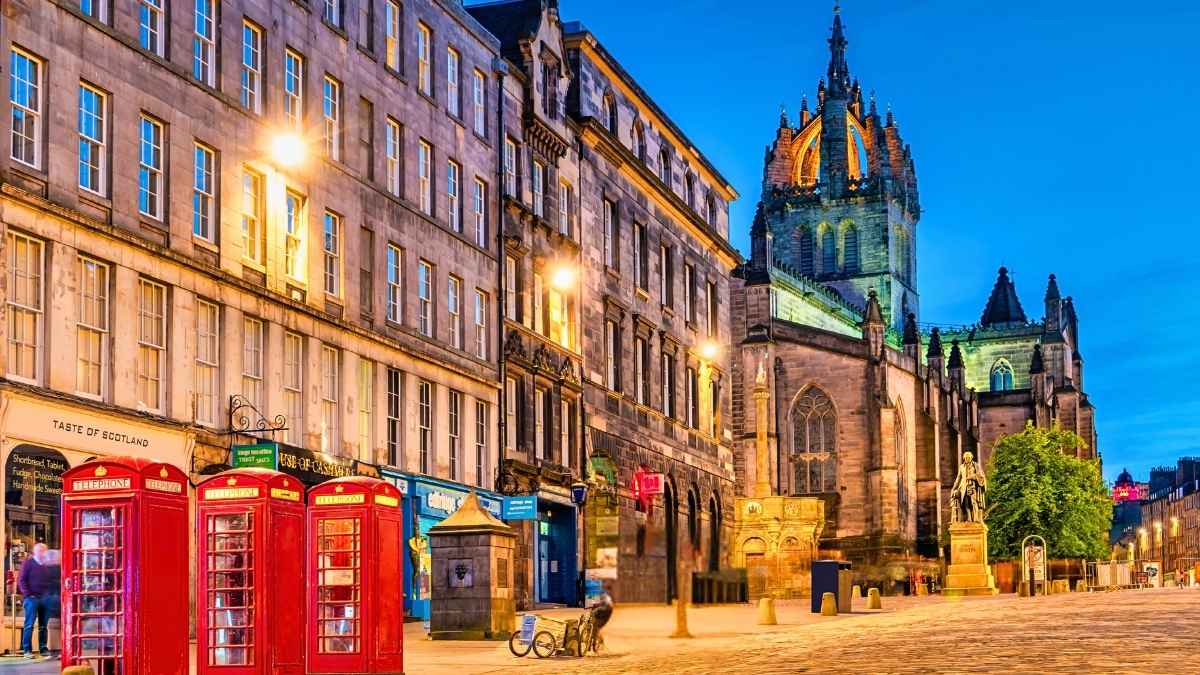 City street with phone boxes and people at night