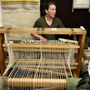 Woman working a loom with yarn