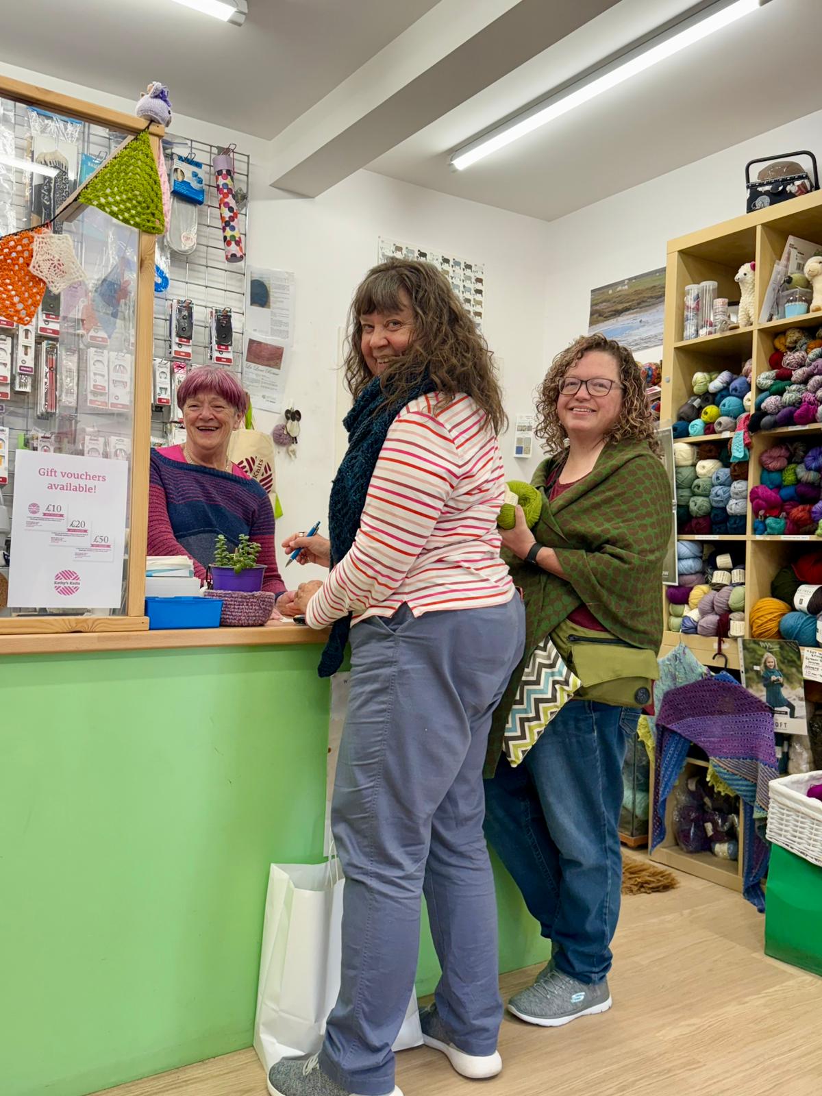 Women shopping in yarn store at counter