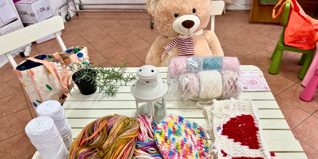 Teddy bear and knitting supplies on a white table