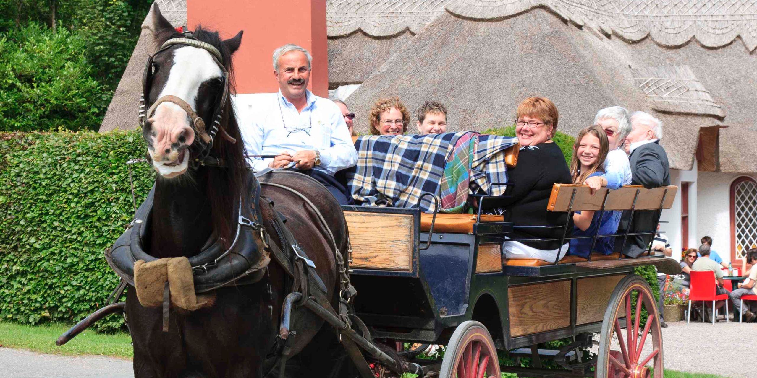 Visitors enjoying a traditional horse and carriage ride through an Irish village.