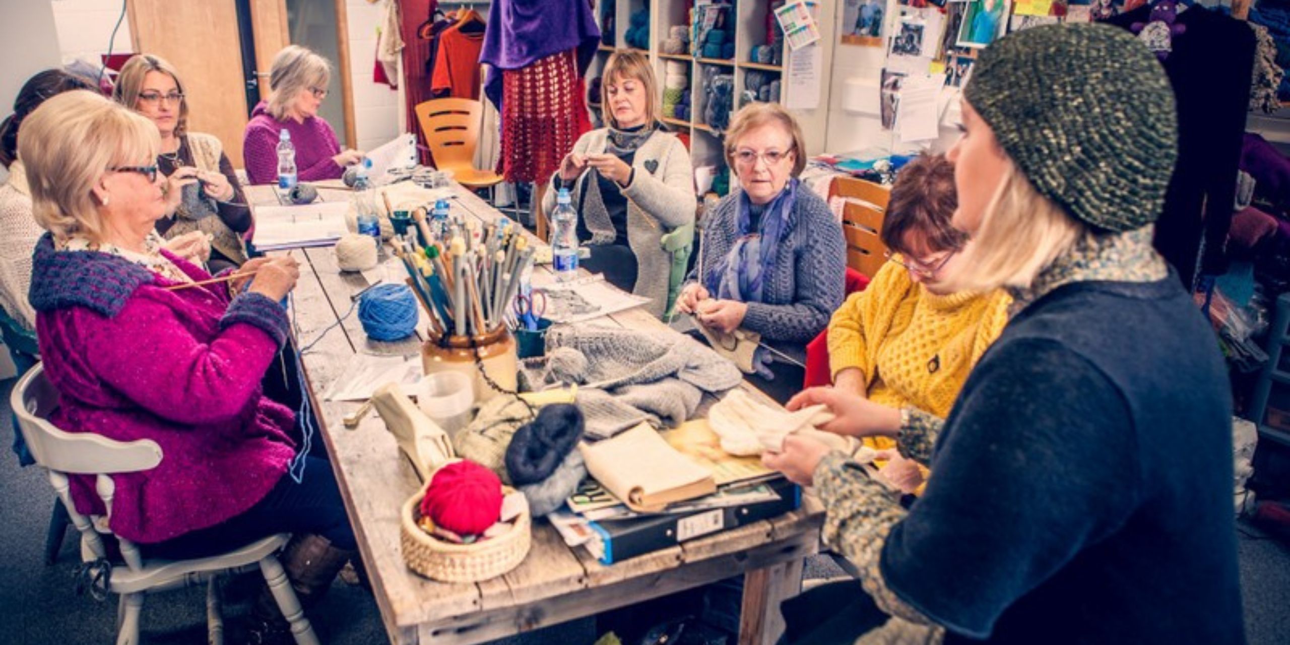 Knitters taking part in an expert-led knitting workshop in Ireland, learning traditional techniques with Irish wool and handmade garments.
