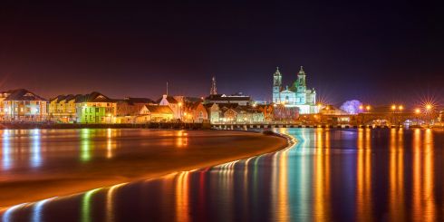 Town lit up at night from the river