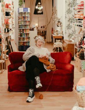 Female smiling and knitting in yarn store